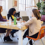 Colleagues in industrial office building working at desk